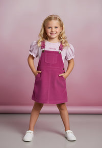 Brighten up your little girl’s summer wardrobe with the Cherry Crumble Lavender Dungaree Dress, a charming and comfortable outfit crafted for all-day wear.