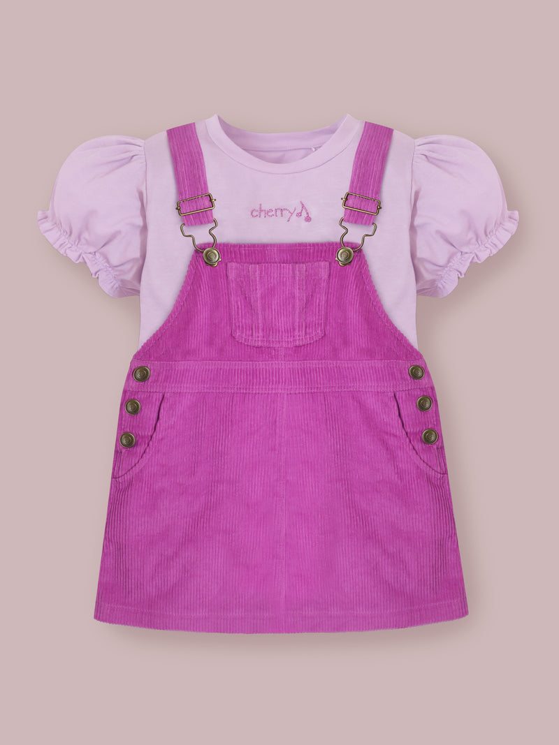 Brighten up your little girl’s summer wardrobe with the Cherry Crumble Lavender Dungaree Dress, a charming and comfortable outfit crafted for all-day wear.